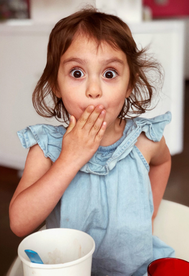 Girl with brown eyes covering her mouth