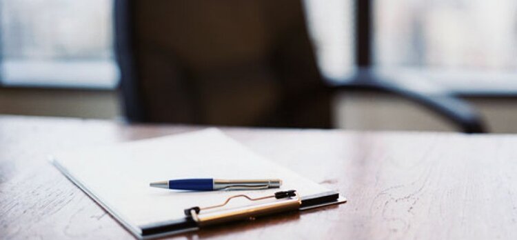 A pen and clipboard on a table