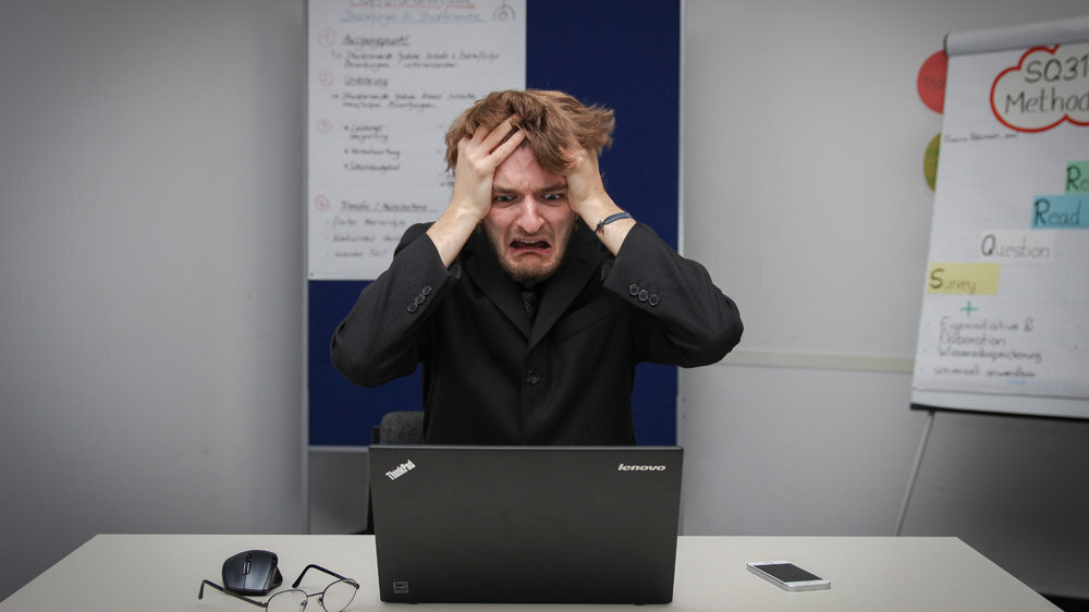 Frustrated man in front of a laptop